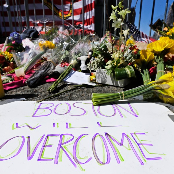 2013年4月17日，波士顿，两起爆炸造成3人死亡，数百人受伤，两天后，波士顿马拉松赛终点线附近的一个临时纪念爆炸受害者和幸存者的纪念碑上装饰着鲜花和标志。2023年4月17日是波士顿马拉松爆炸案十周年，届时将在终点线敬献花圈，以纪念遇难者，并将举办社区服务日，公众将聚集在一起反思这场悲剧。beplay手机app维护(美联社图片/查尔斯·克鲁帕，档案)
