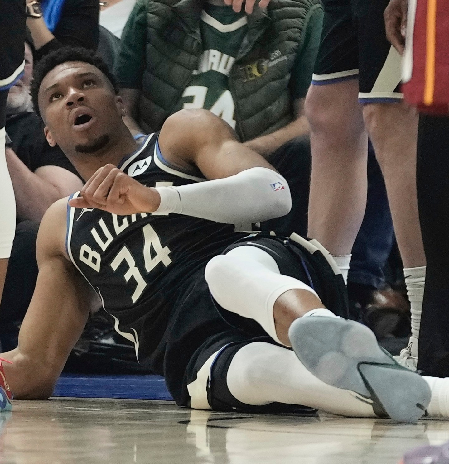 2023年4月16日，密尔沃基，密尔沃基雄鹿队的“字母哥”在NBA篮球季后赛首轮第一场比赛的上半场受伤后躺在地上。(美联社图片/Morry Gash)