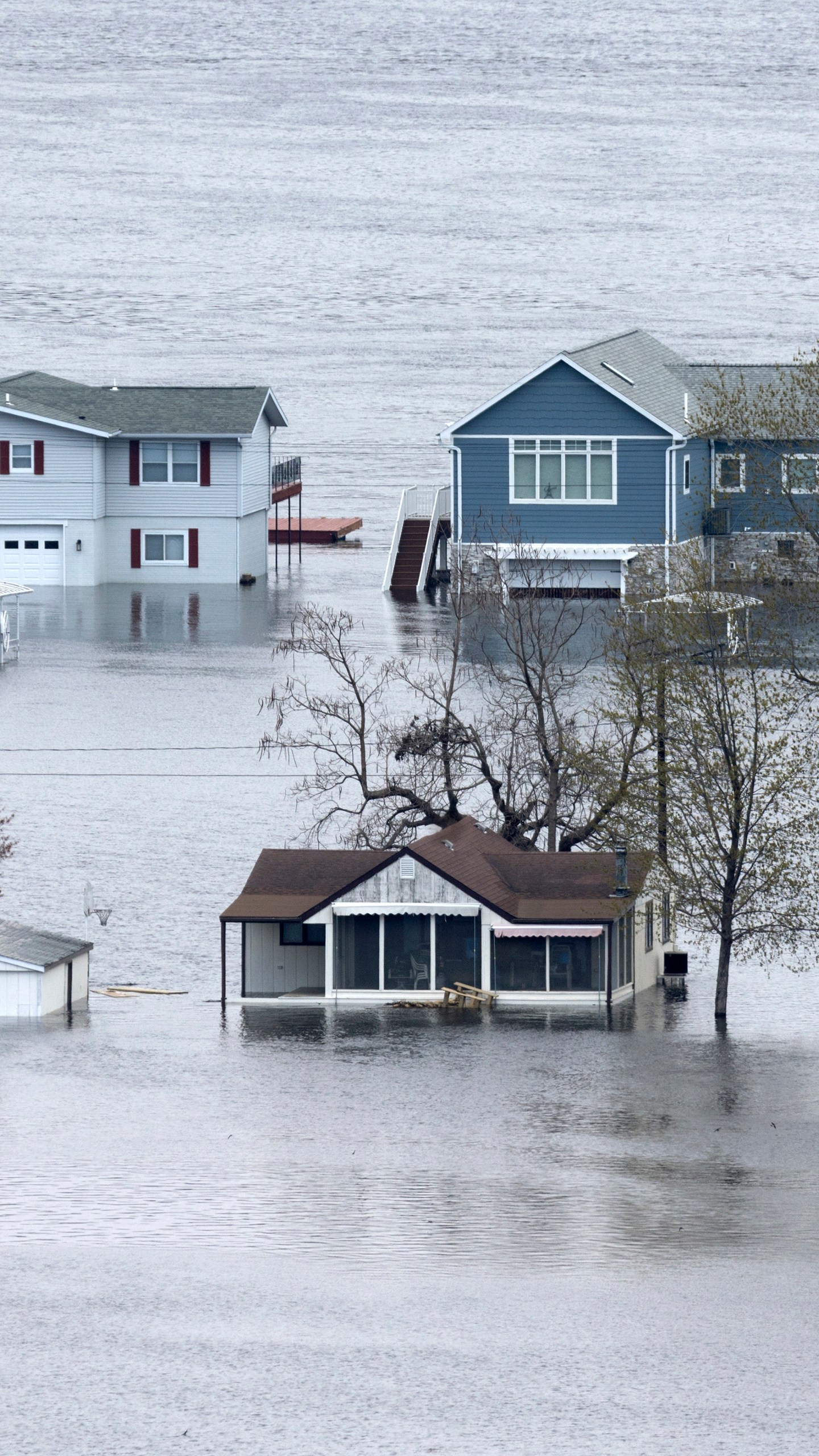 2023年4月25日，星期二，爱荷华州古滕堡附近的阿贝尔岛上，被洪水淹没的密西西比河包围着房屋。(斯蒂芬·加斯曼/美联社《每日电讯报先驱报》)