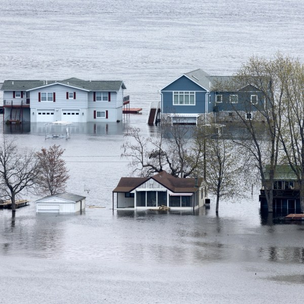 2023年4月25日，星期二，爱荷华州古滕堡附近的阿贝尔岛上，被洪水淹没的密西西比河包围着房屋。(斯蒂芬·加斯曼/美联社《每日电讯报先驱报》)